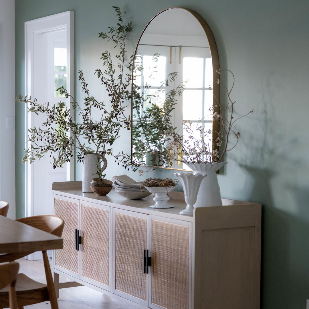 a dining room with a table and a mirror