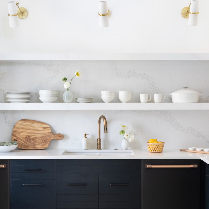 a kitchen with black cabinets and white walls