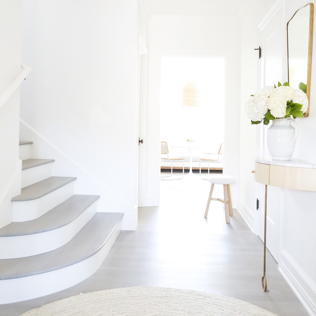 a white room with a staircase and a mirror