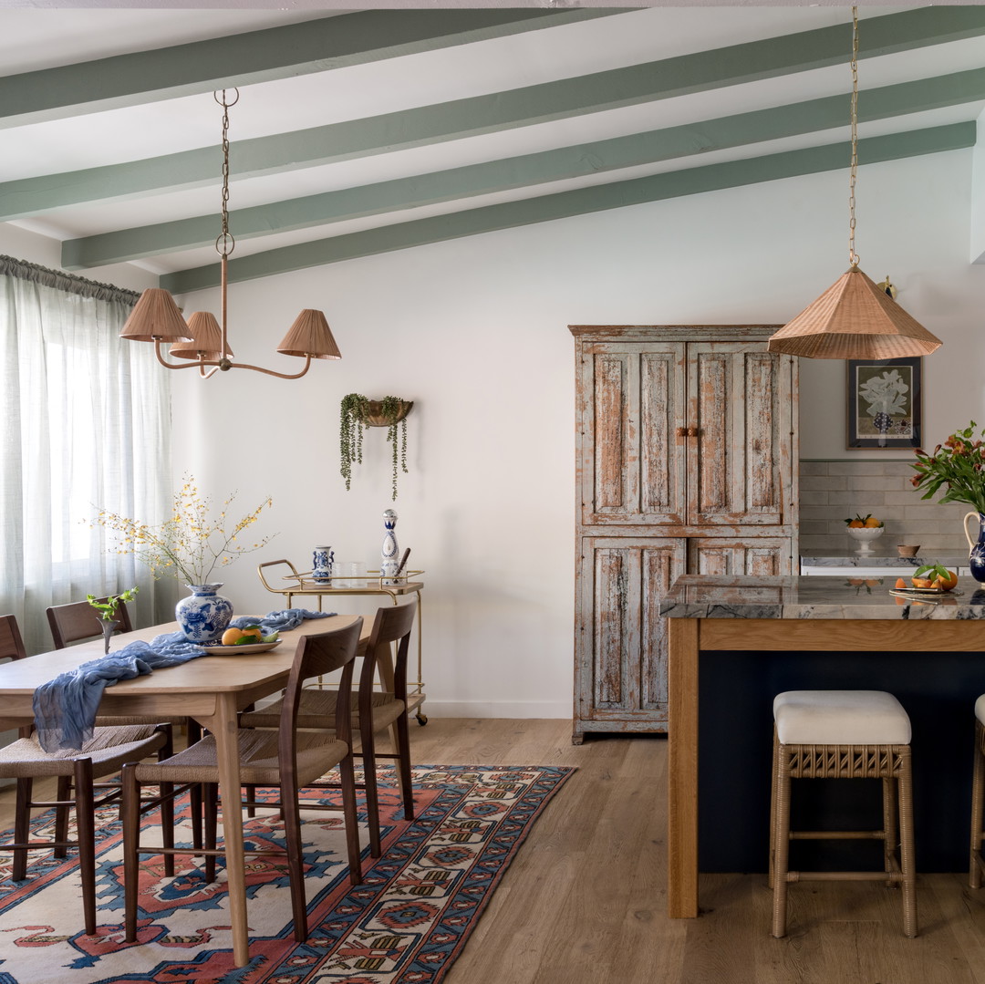 a kitchen with a table and chairs and a rug on the floor