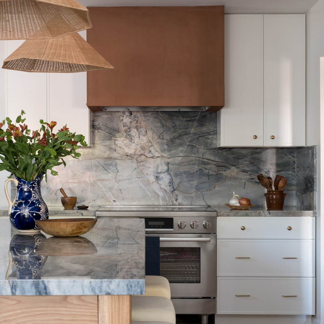 a kitchen with a marble counter top and wooden cabinets