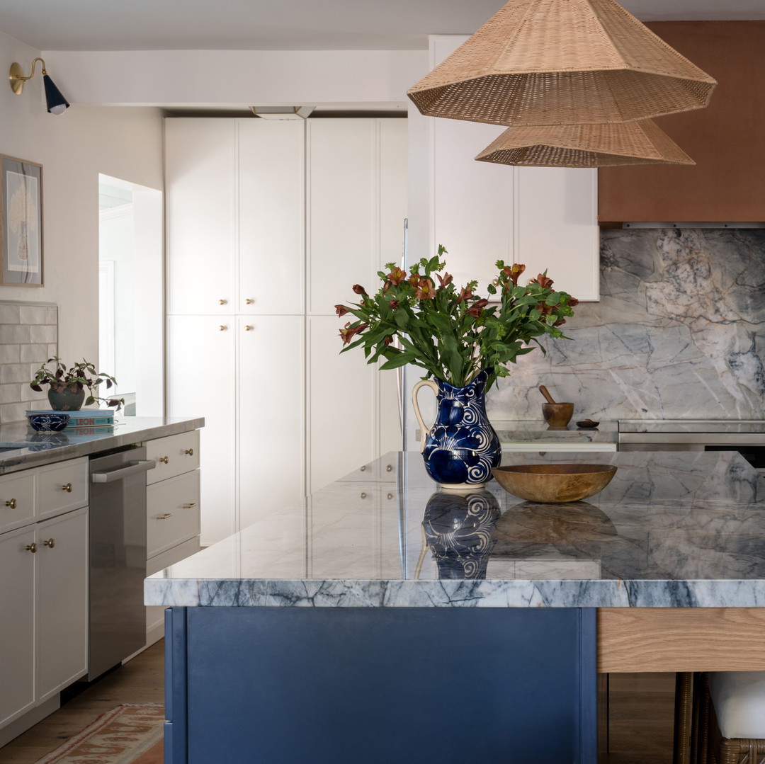 a kitchen with marble counter tops and white cabinets