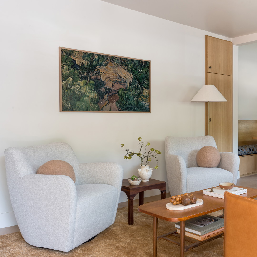 a living room filled with furniture and a painting on the wall