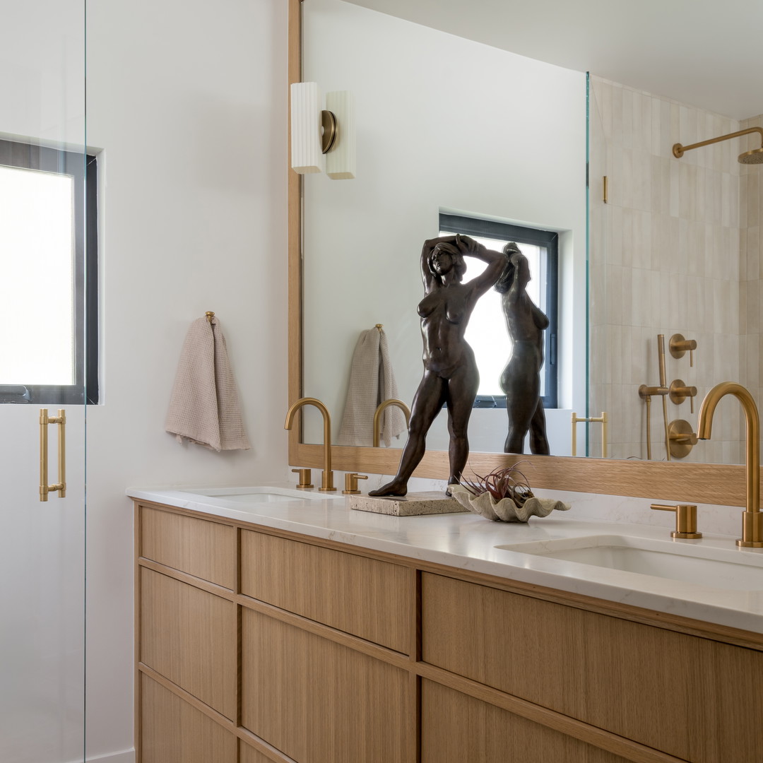 a bathroom with a large mirror and a statue on the counter