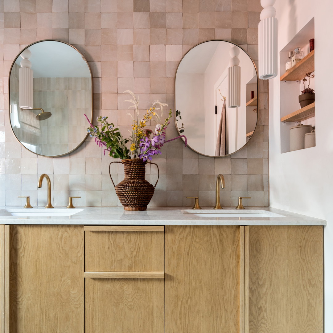 a bathroom with two round mirrors above a sink