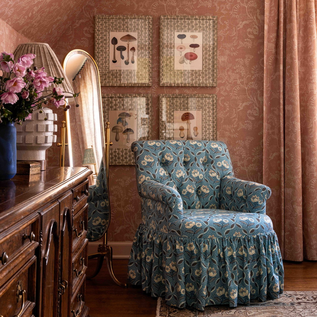 a blue chair sitting in a living room next to a window