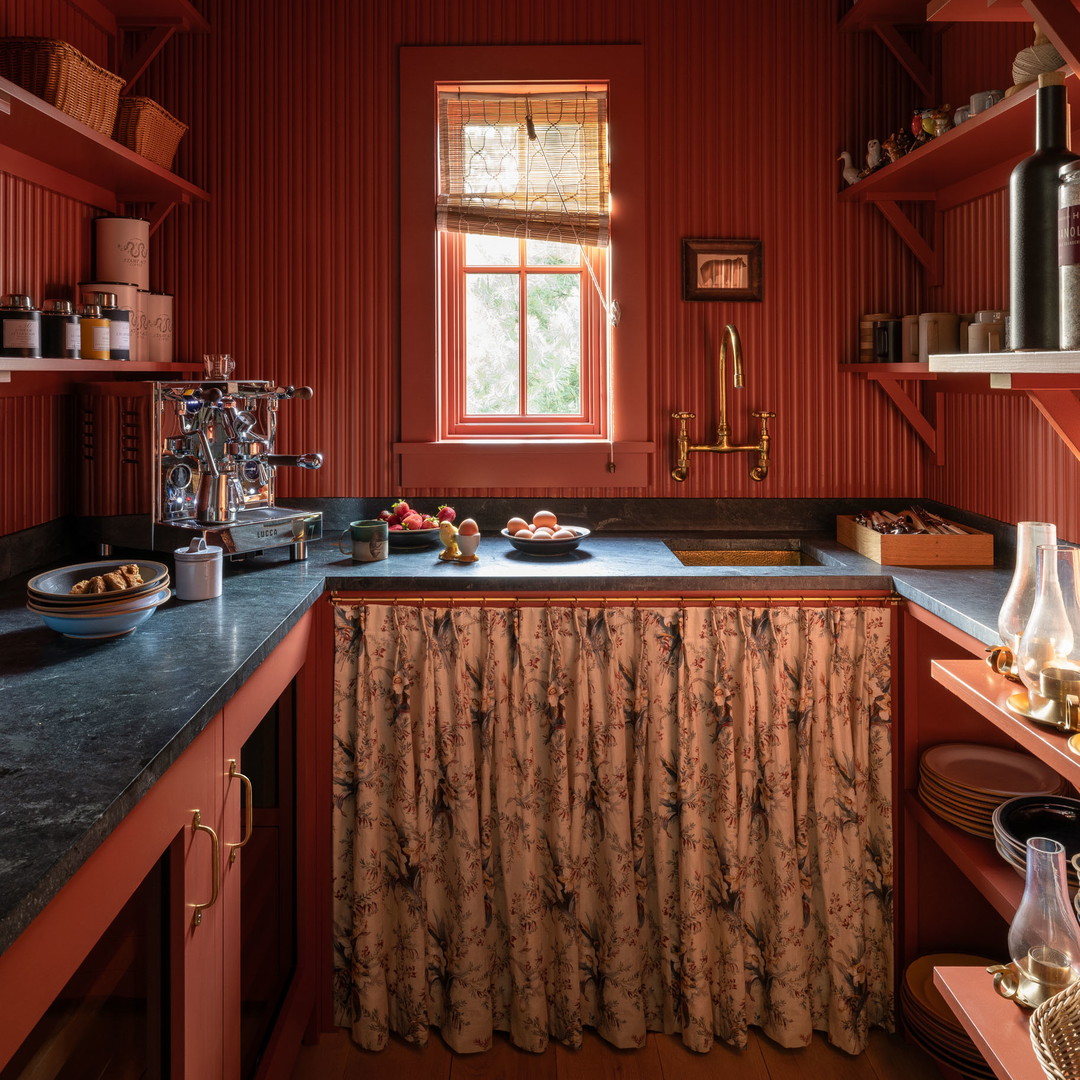 a kitchen with red walls and a black counter top