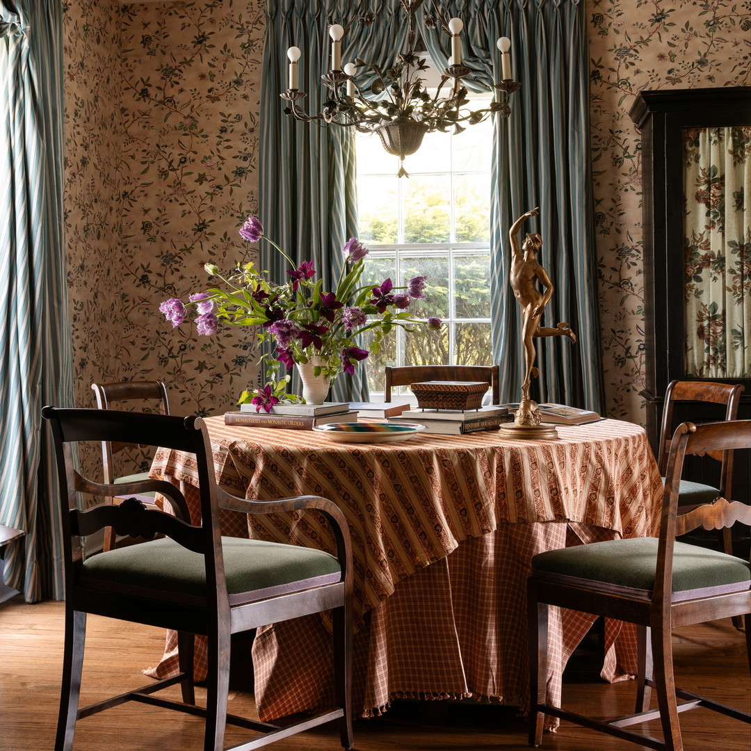 a dining room with a table, chairs and a chandelier