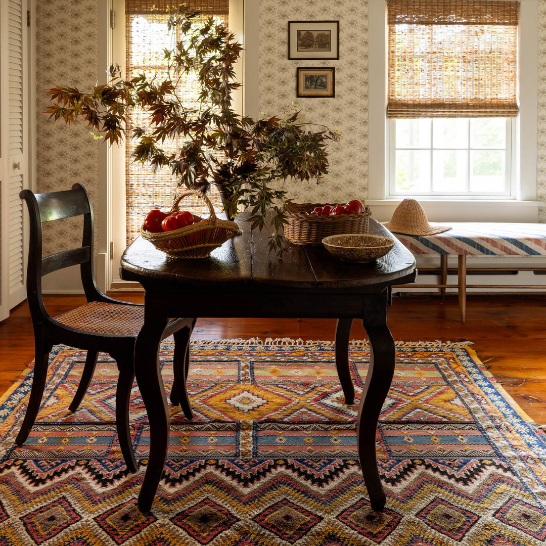 a dining room table with a basket of fruit on top of it