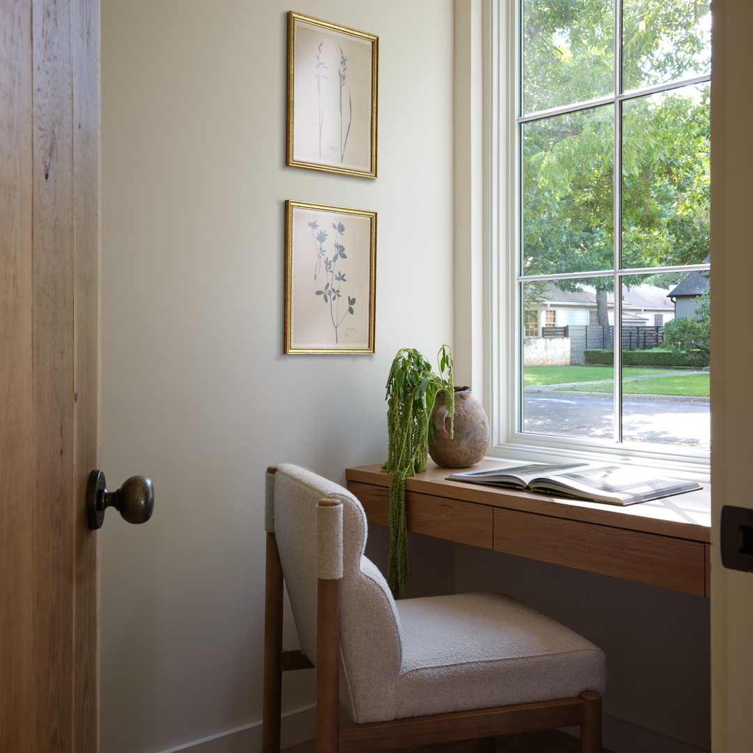a room with a desk, chair and a window