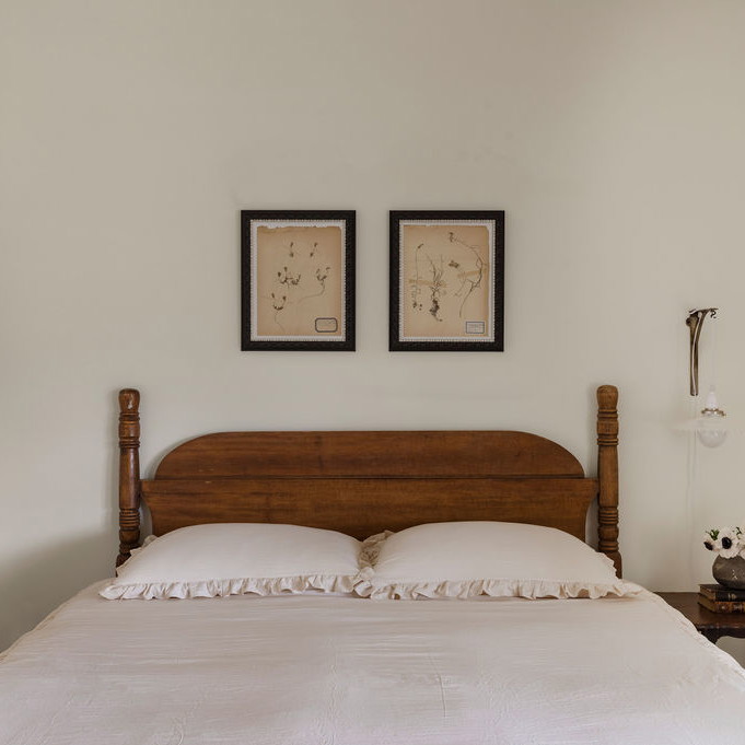 a bed with two pictures on the wall above it