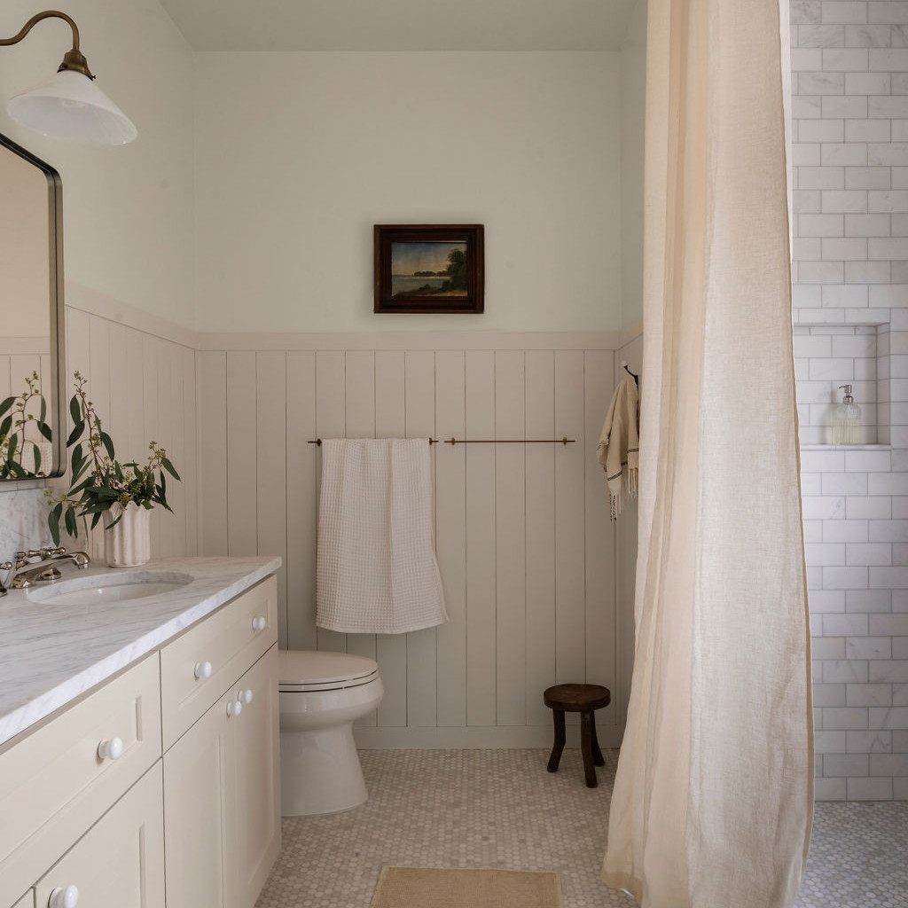 a bathroom with a toilet, sink, and shower curtain