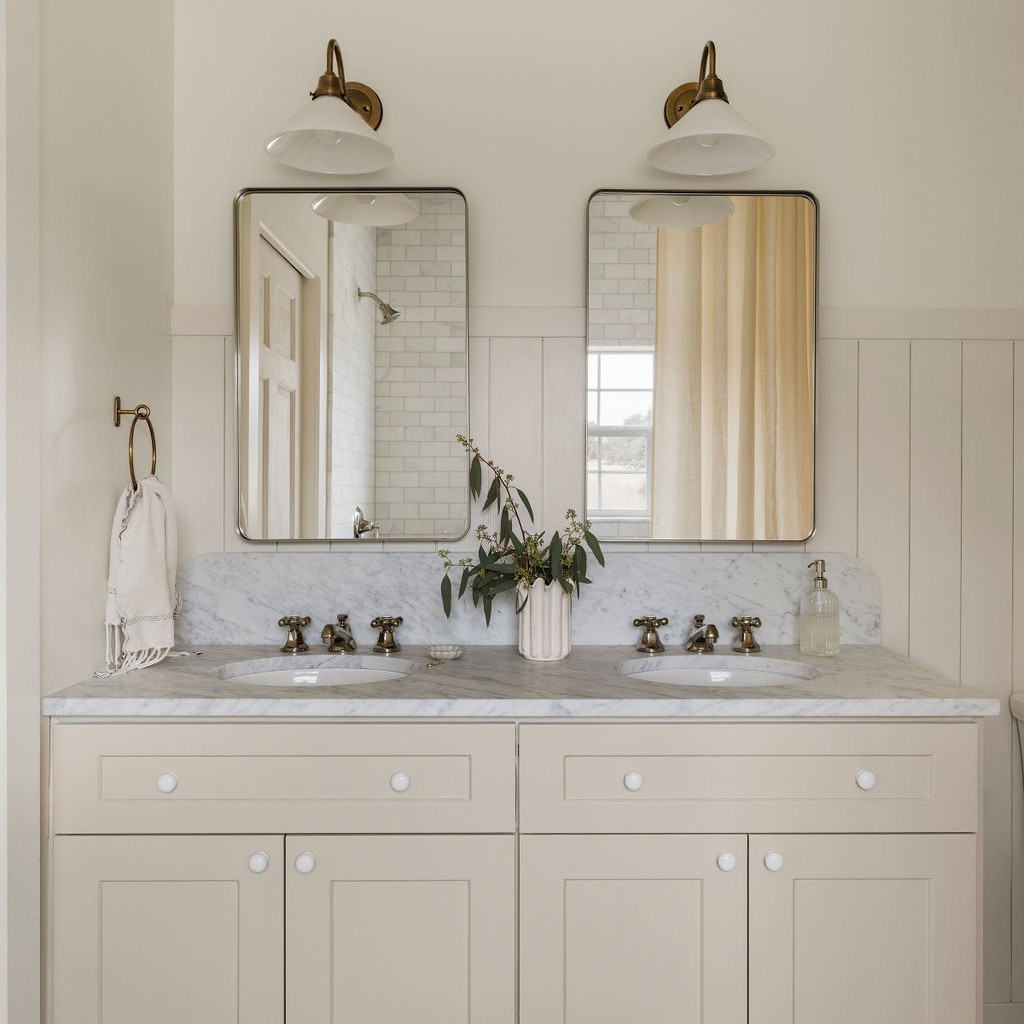 a bathroom with two sinks and two mirrors