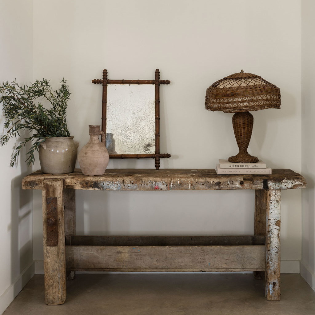 a table with a mirror, vases and a lamp on it