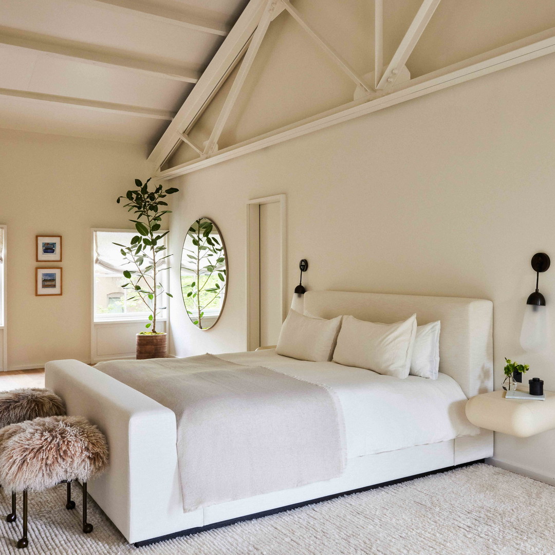 a bedroom with a white bed and a white rug