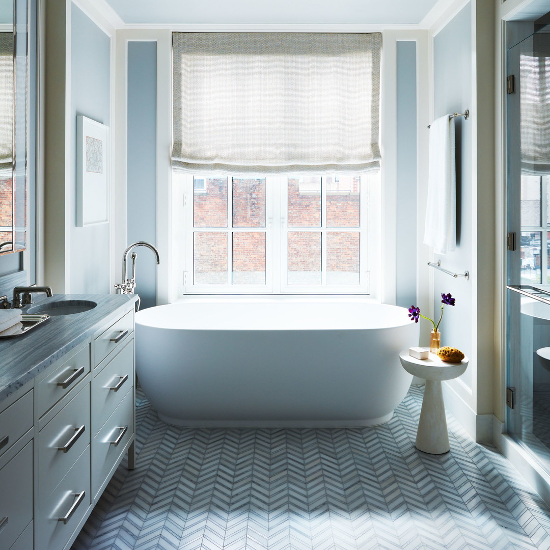 a bathroom with a tub, sink, and window