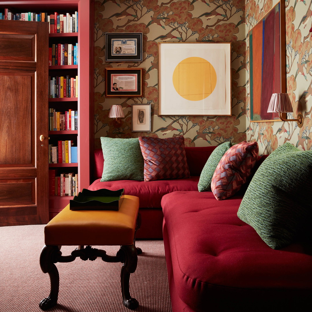 a living room with a red couch and bookshelf