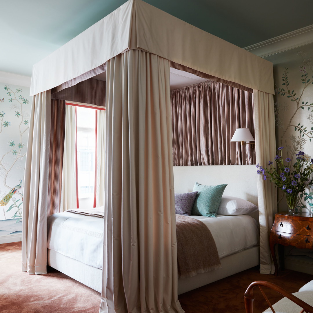 a bedroom with a canopy bed and a chair