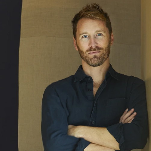 a man standing in a room with his arms crossed