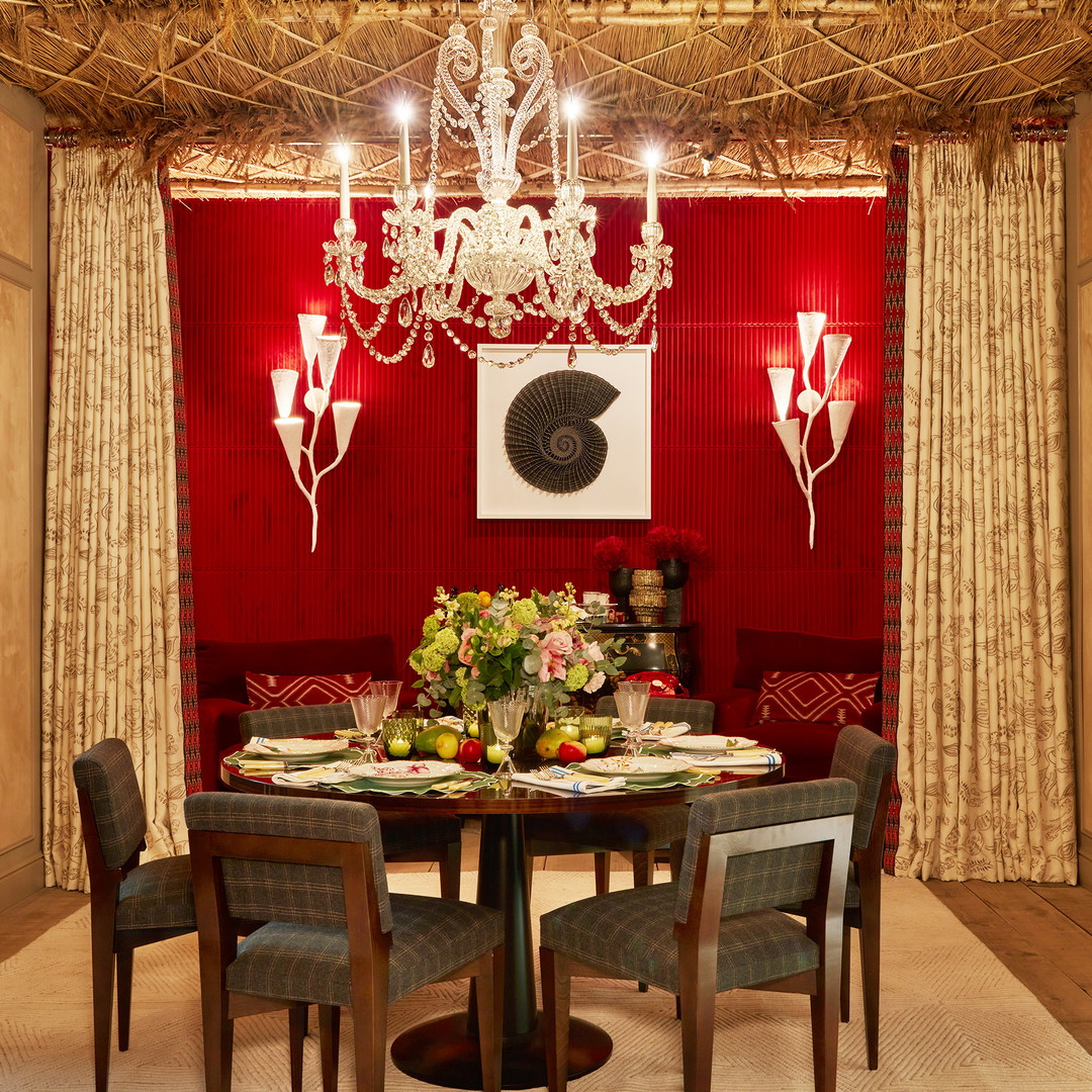 a dining room with red walls and a chandelier