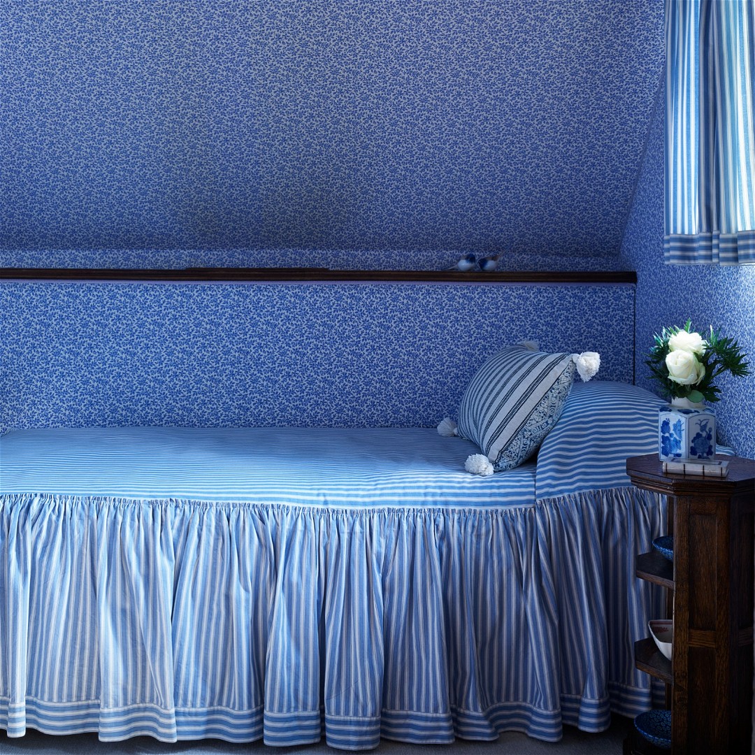 a blue and white bedroom with a twin bed