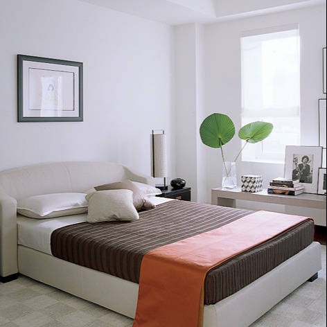 a bedroom with a white bed and a white couch
