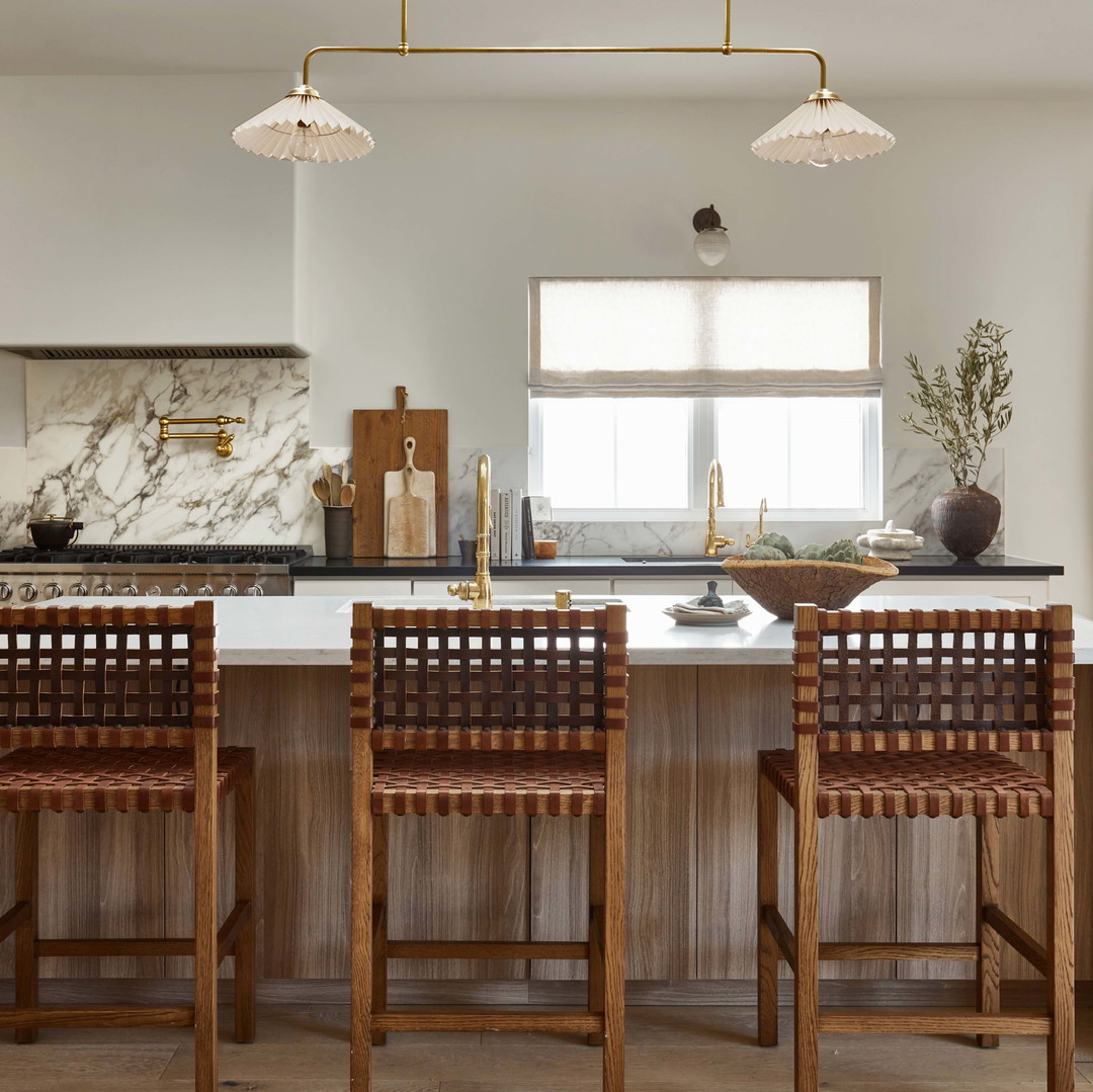 a large kitchen with a center island and wooden chairs