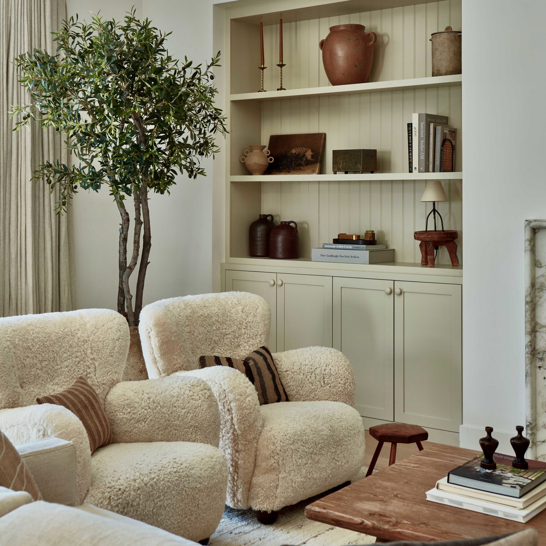 a living room filled with furniture and a tree