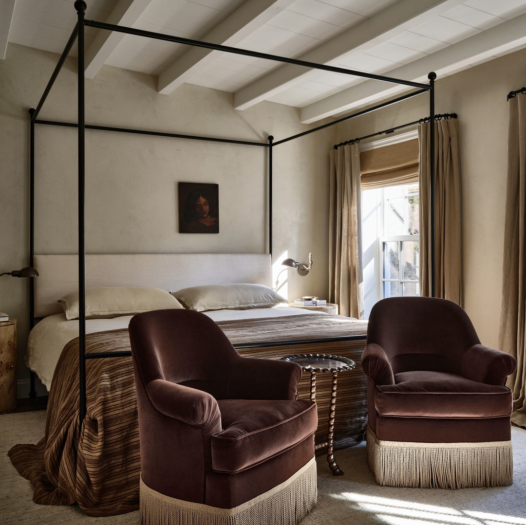 a bedroom with a canopy bed and two chairs