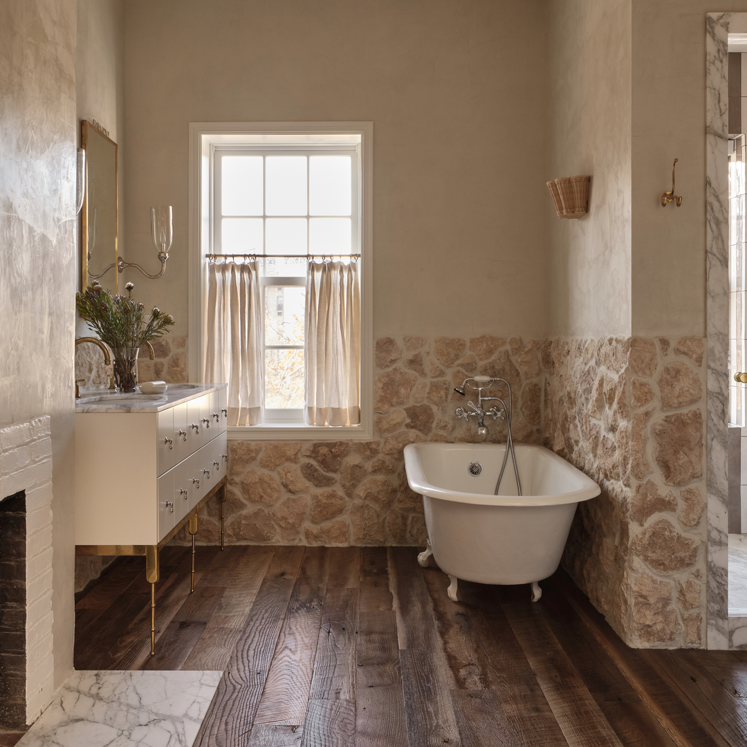 a bathroom with a tub, sink, and window