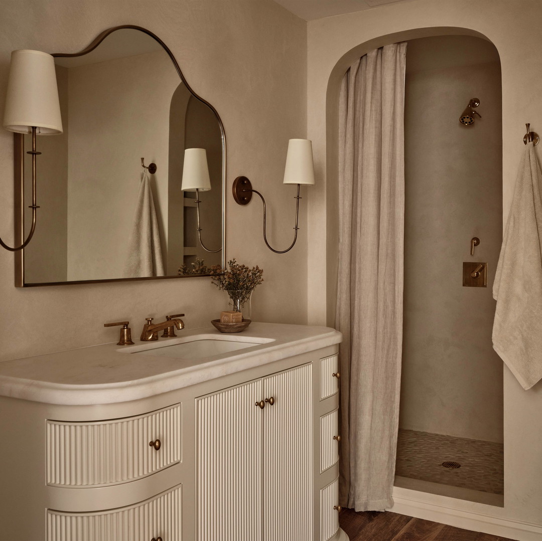 a bathroom with a shower, sink and mirror