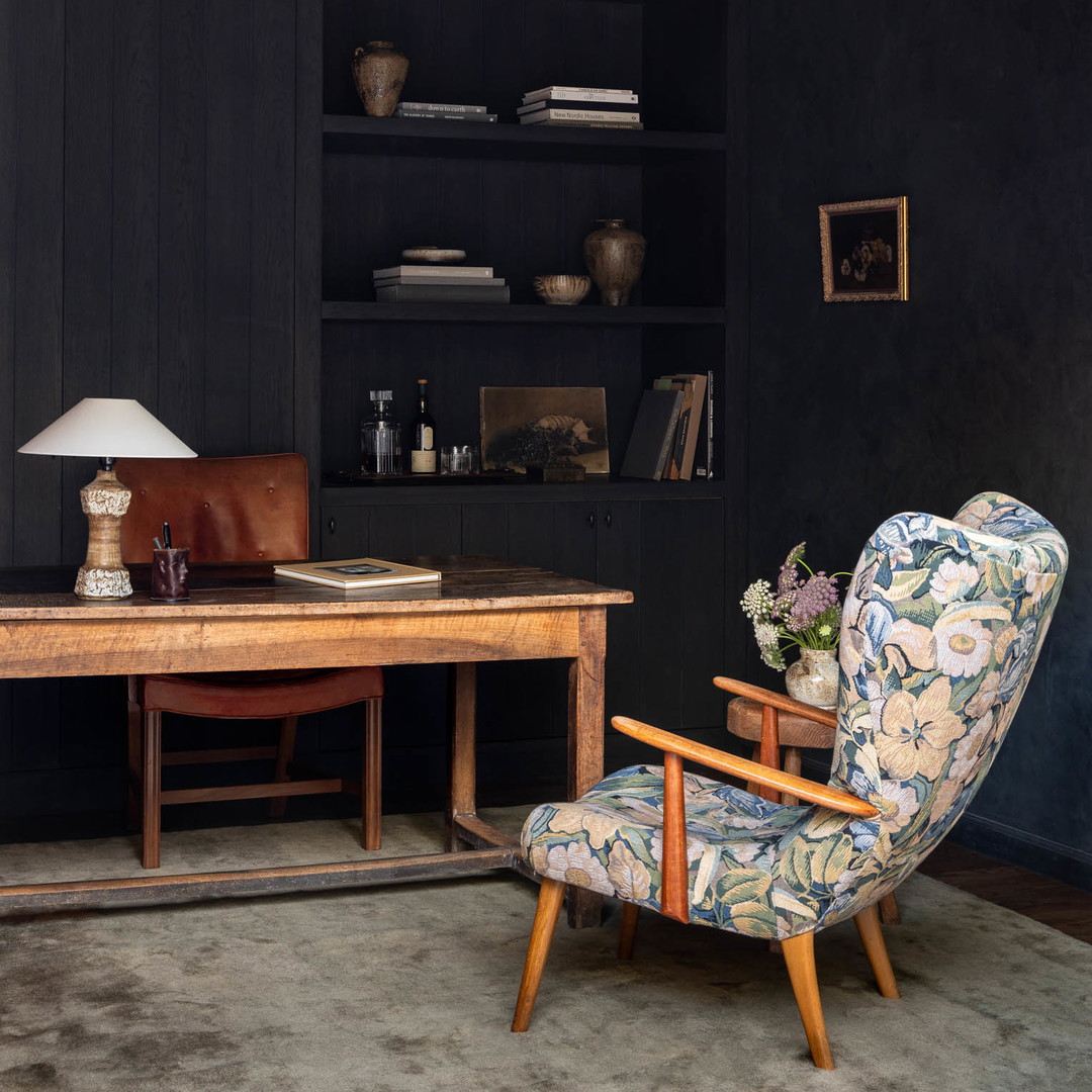 a room with a desk, chair, and bookcase