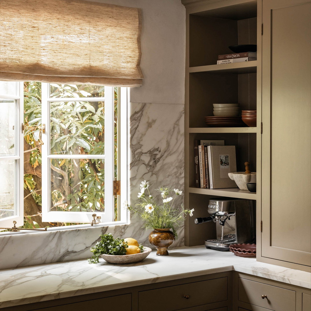 a kitchen with marble counter tops and a window