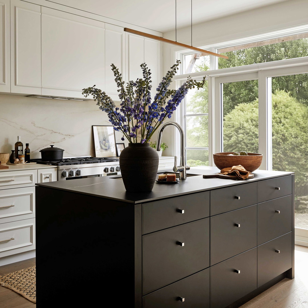 a kitchen island with a vase of flowers on top of it