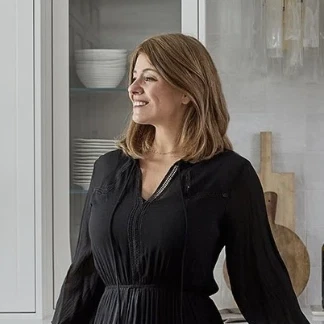 a woman in a black dress standing in a kitchen