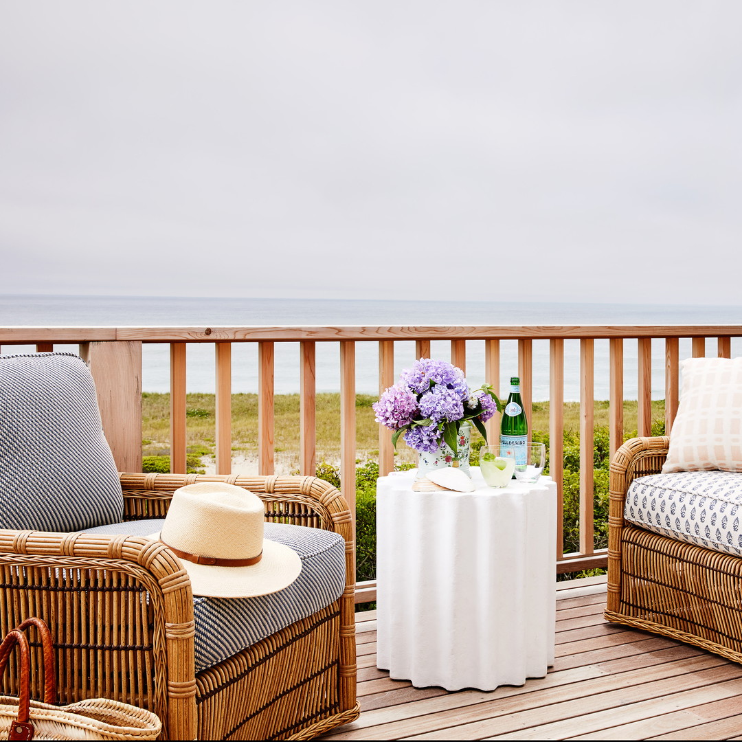 a couple of wicker chairs sitting on top of a wooden deck