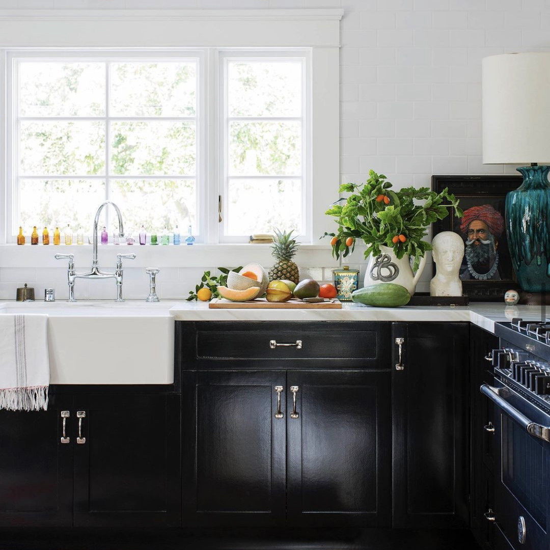 a kitchen with black cabinets and a white sink