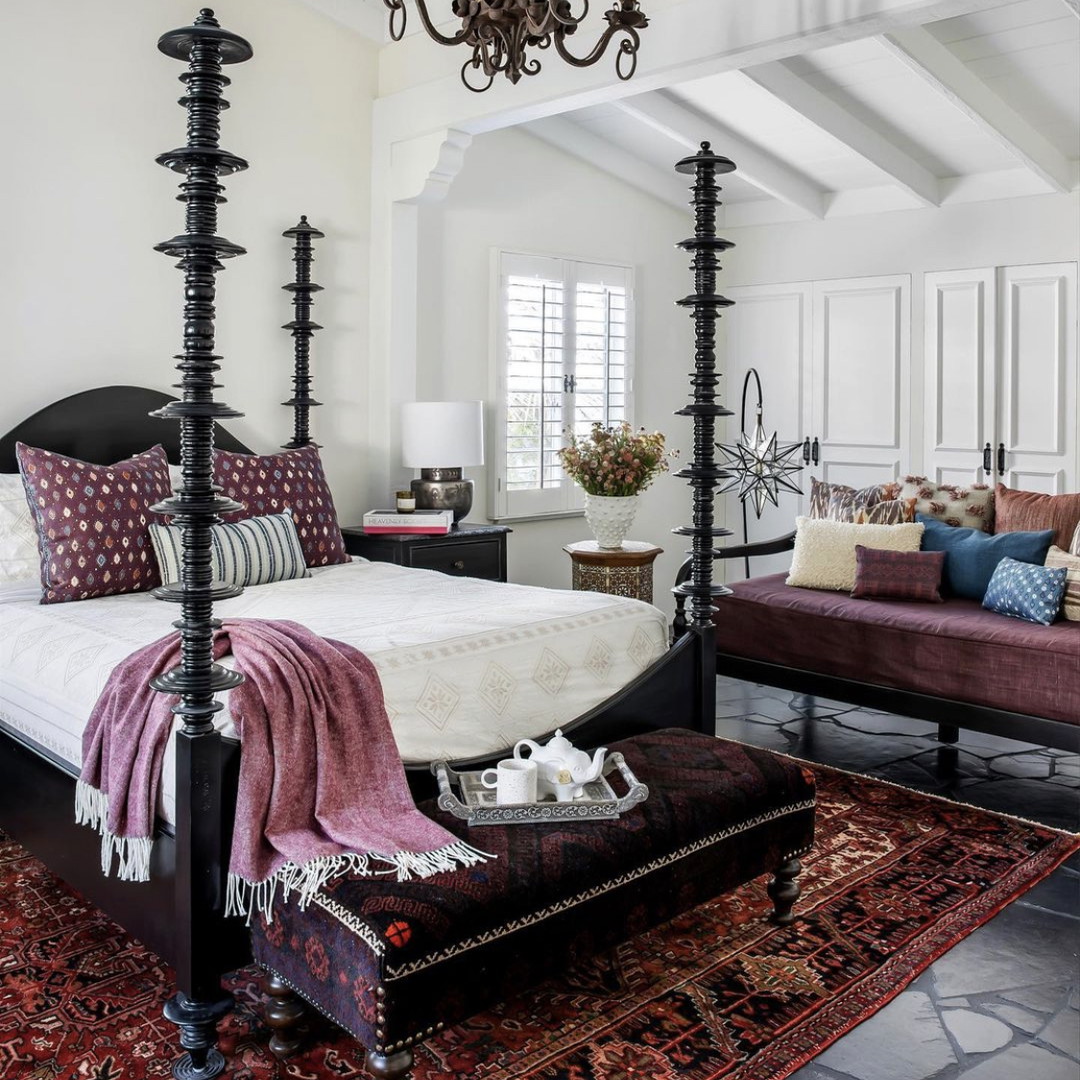 a bedroom with a bed, couch and a chandelier