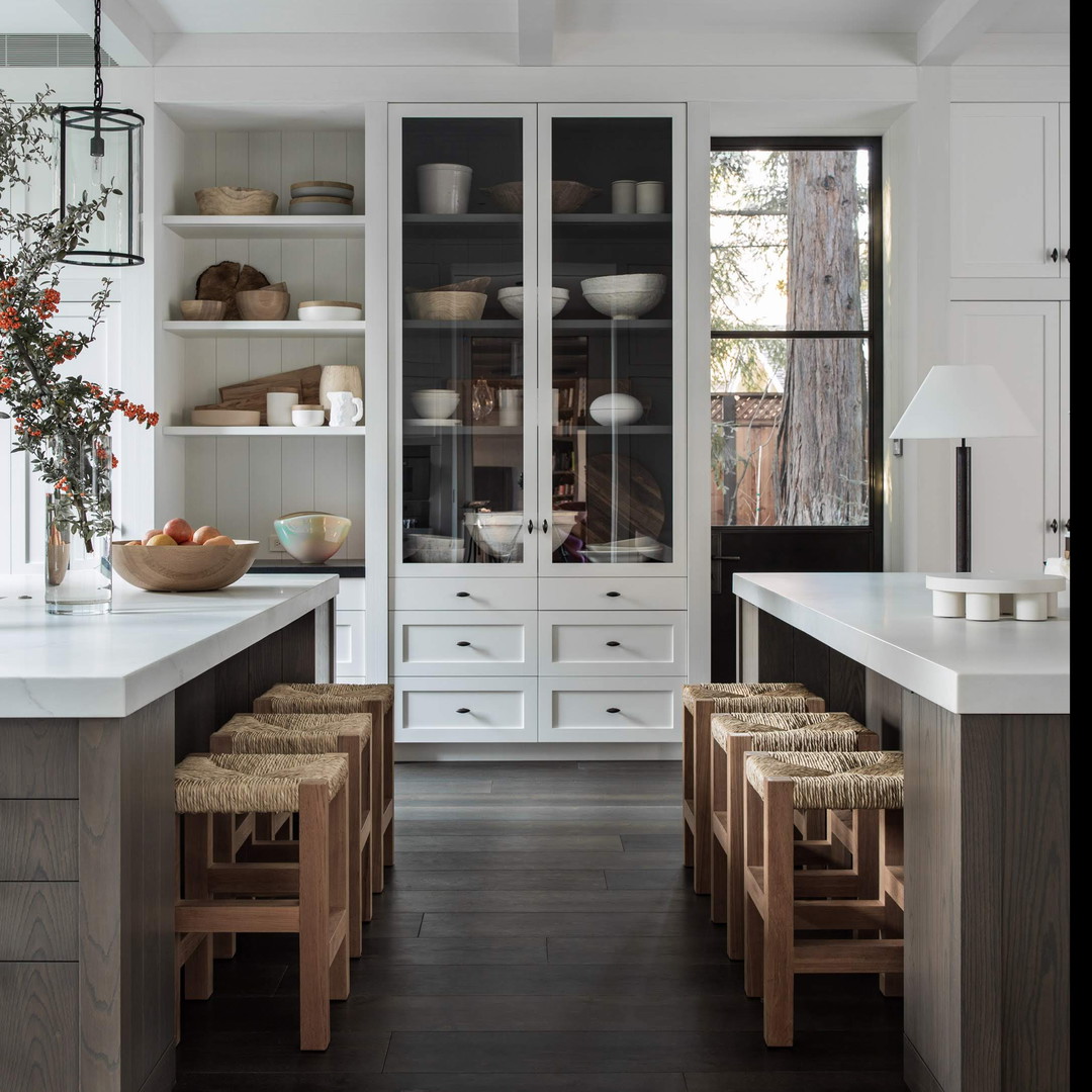 a kitchen with white cabinets and wooden floors