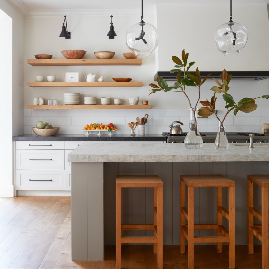 a kitchen with a marble counter top and wooden stools