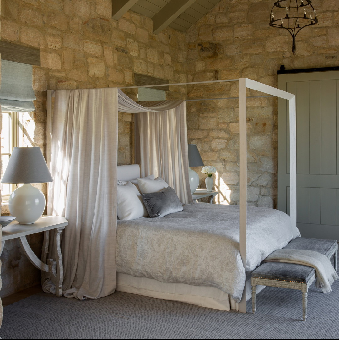 a bedroom with stone walls and a canopy bed