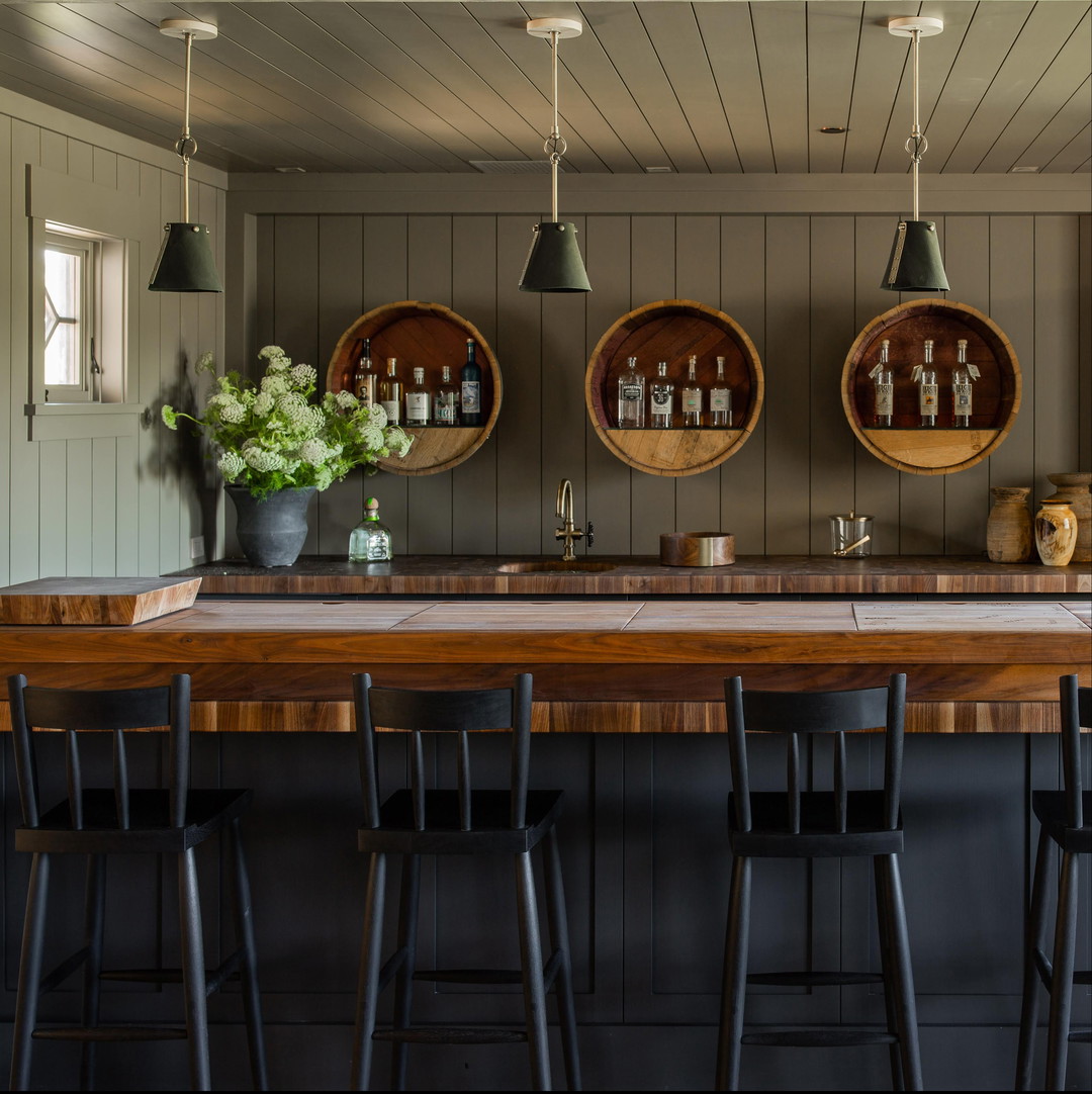 a bar with stools and a table with a vase of flowers