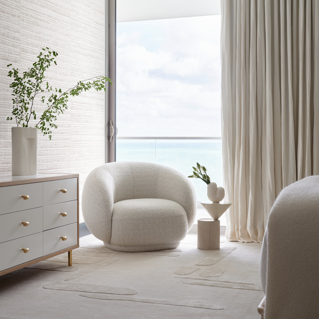 a living room with a large window and a white chair