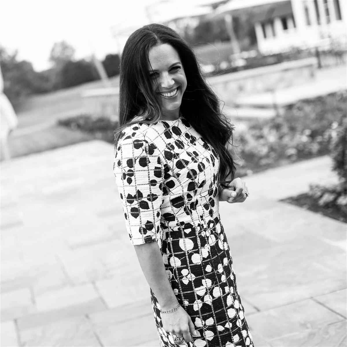 a woman standing on a sidewalk in a dress