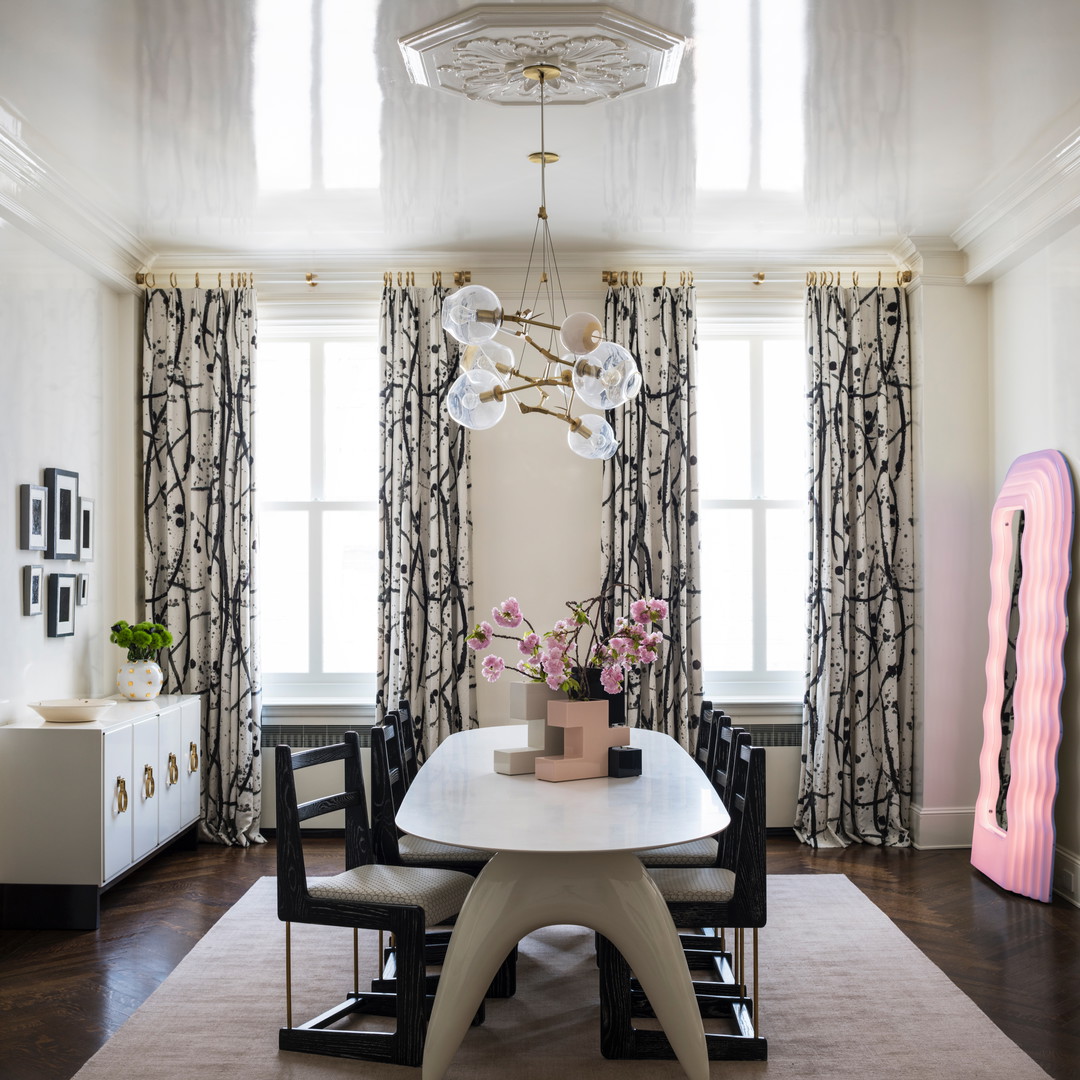 a dining room with a white table and chairs