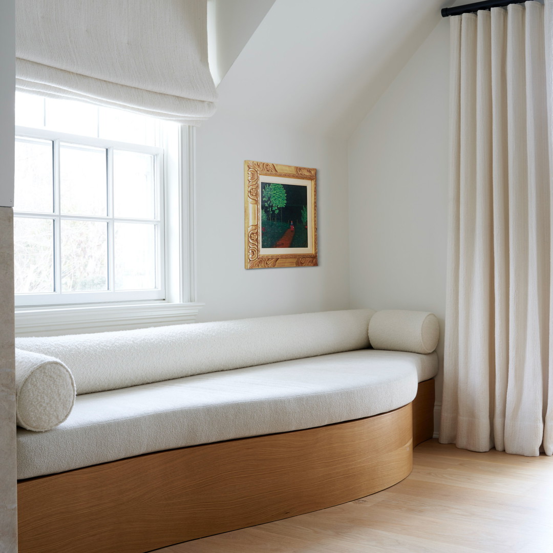 a white couch sitting under a window next to a window