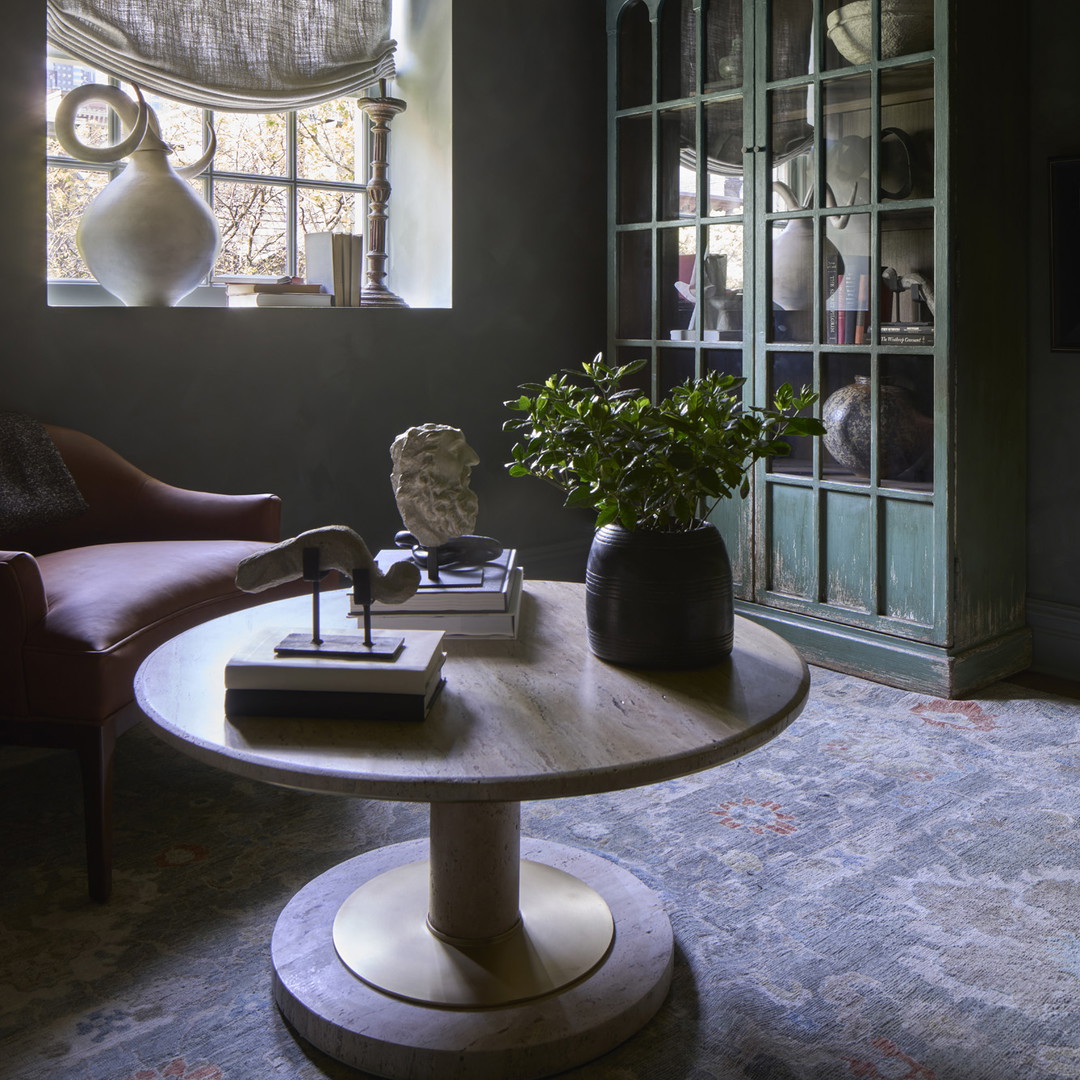 a living room with a table and a chair