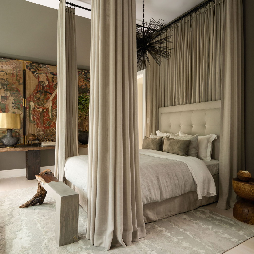 a bedroom with a canopy bed and a painting on the wall