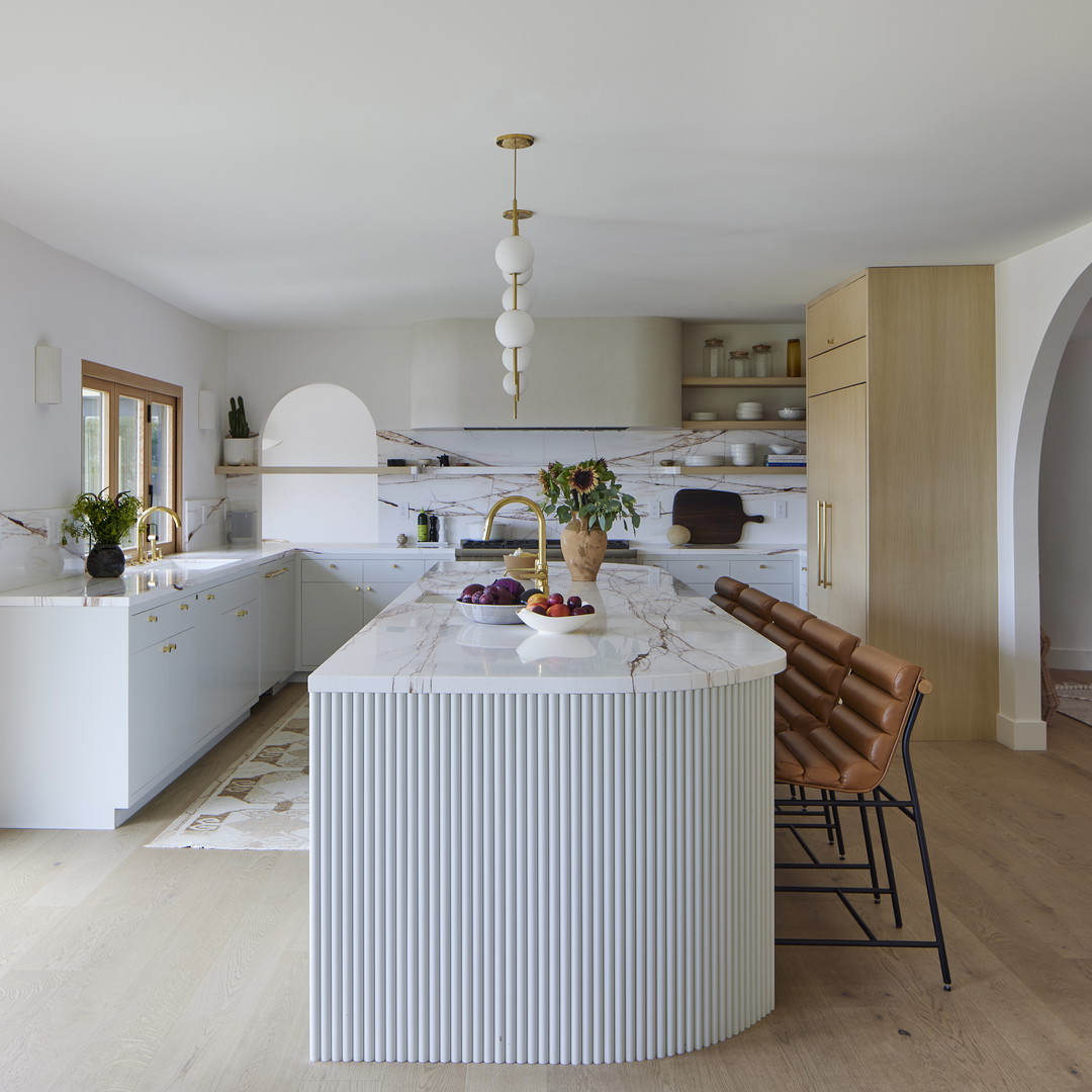 a kitchen with a marble counter top next to a wooden floor