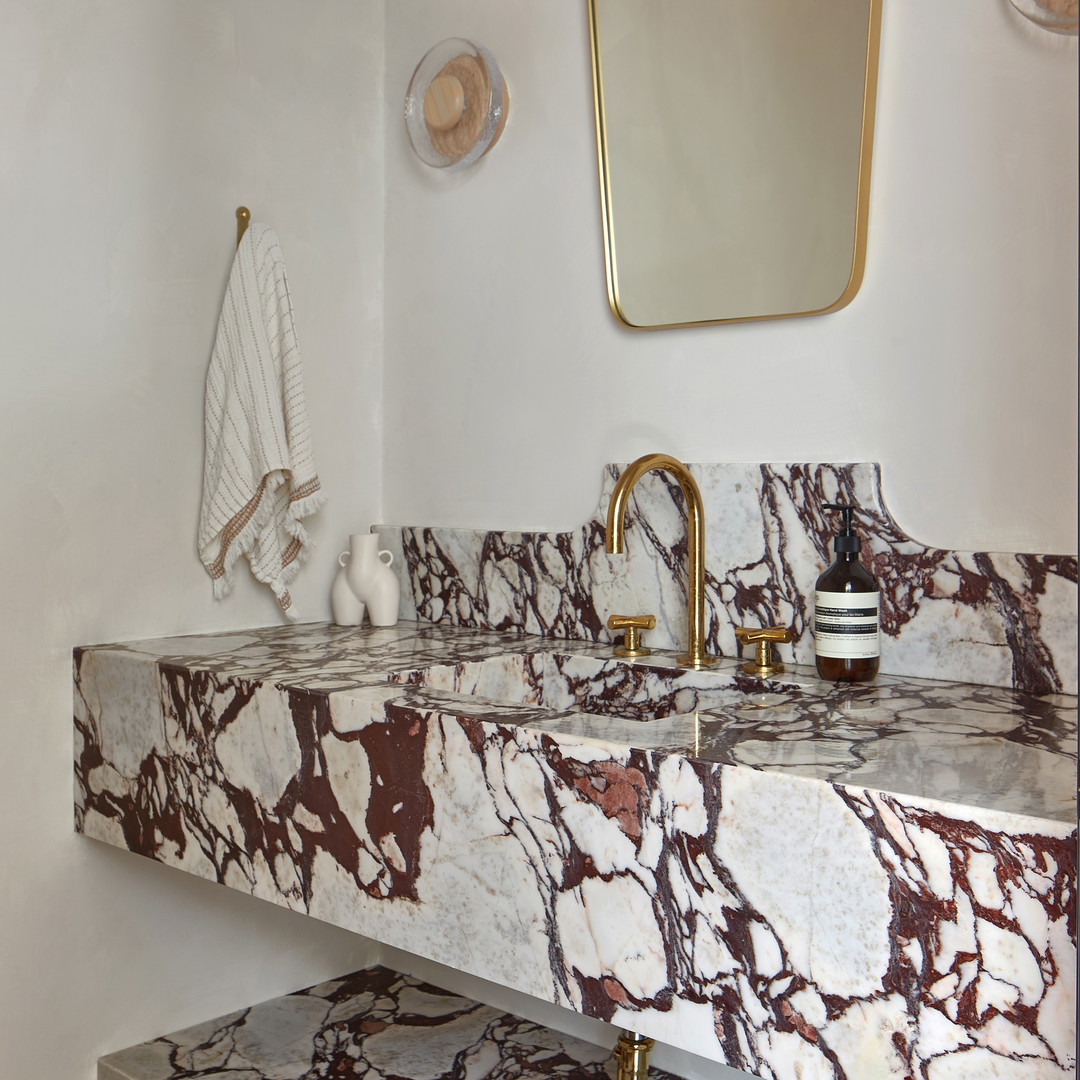 a bathroom with a marble sink and a mirror